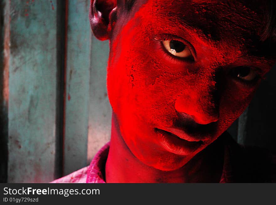 Close up of a boy’s face smeared with red colour during the Holi festival in India. Close up of a boy’s face smeared with red colour during the Holi festival in India.