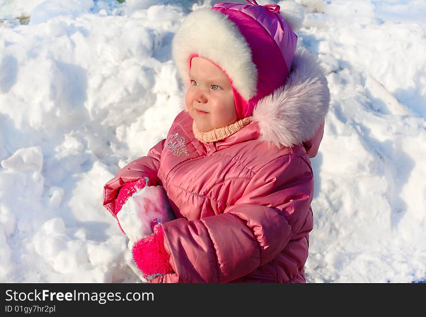 Pretty little girl in winter outerwear play with snow - outdoor portrait. Pretty little girl in winter outerwear play with snow - outdoor portrait.