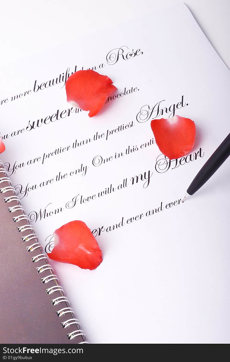 Red rose and a pen on valentine card