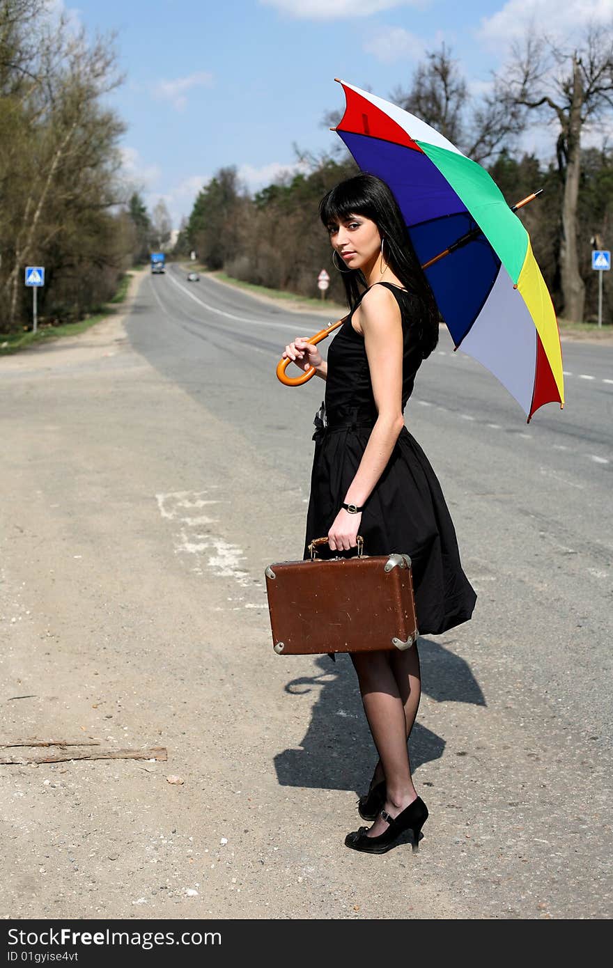 Girl with vintage suitcase and umbrella outdoors. Girl with vintage suitcase and umbrella outdoors