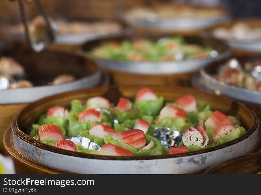 Chinese food being steam in 'steamer baskets'.  This is a form of 'dim sum'.