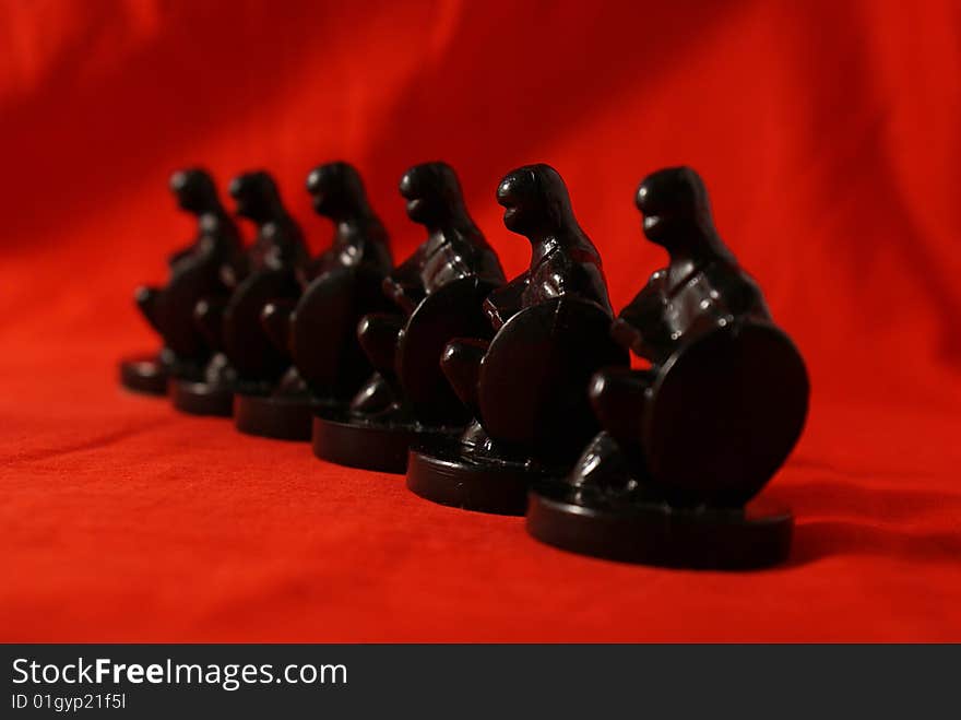 Row of chess figures on red background. Row of chess figures on red background