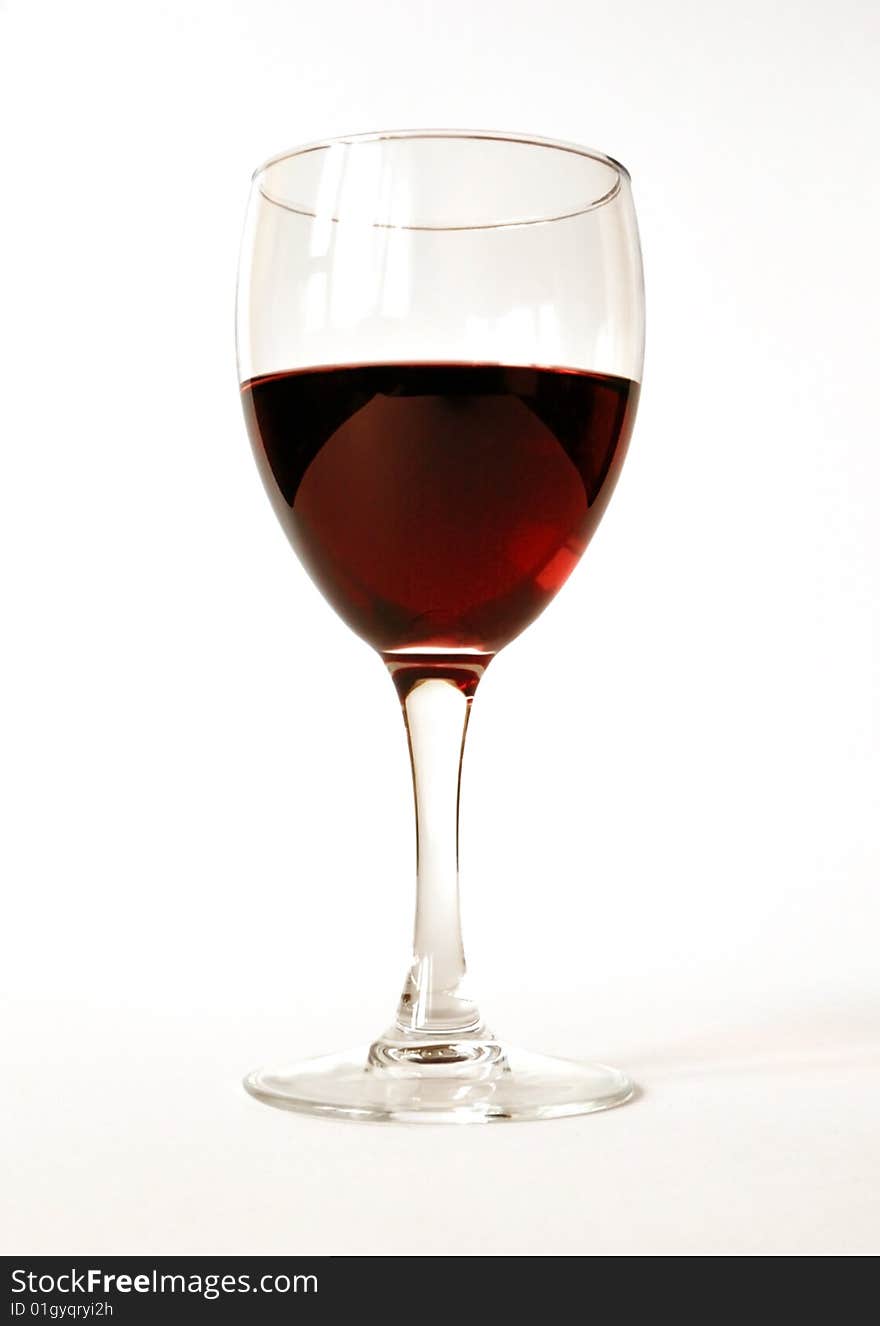 Red semisweet wine in a crystal glass on a white background. Red semisweet wine in a crystal glass on a white background