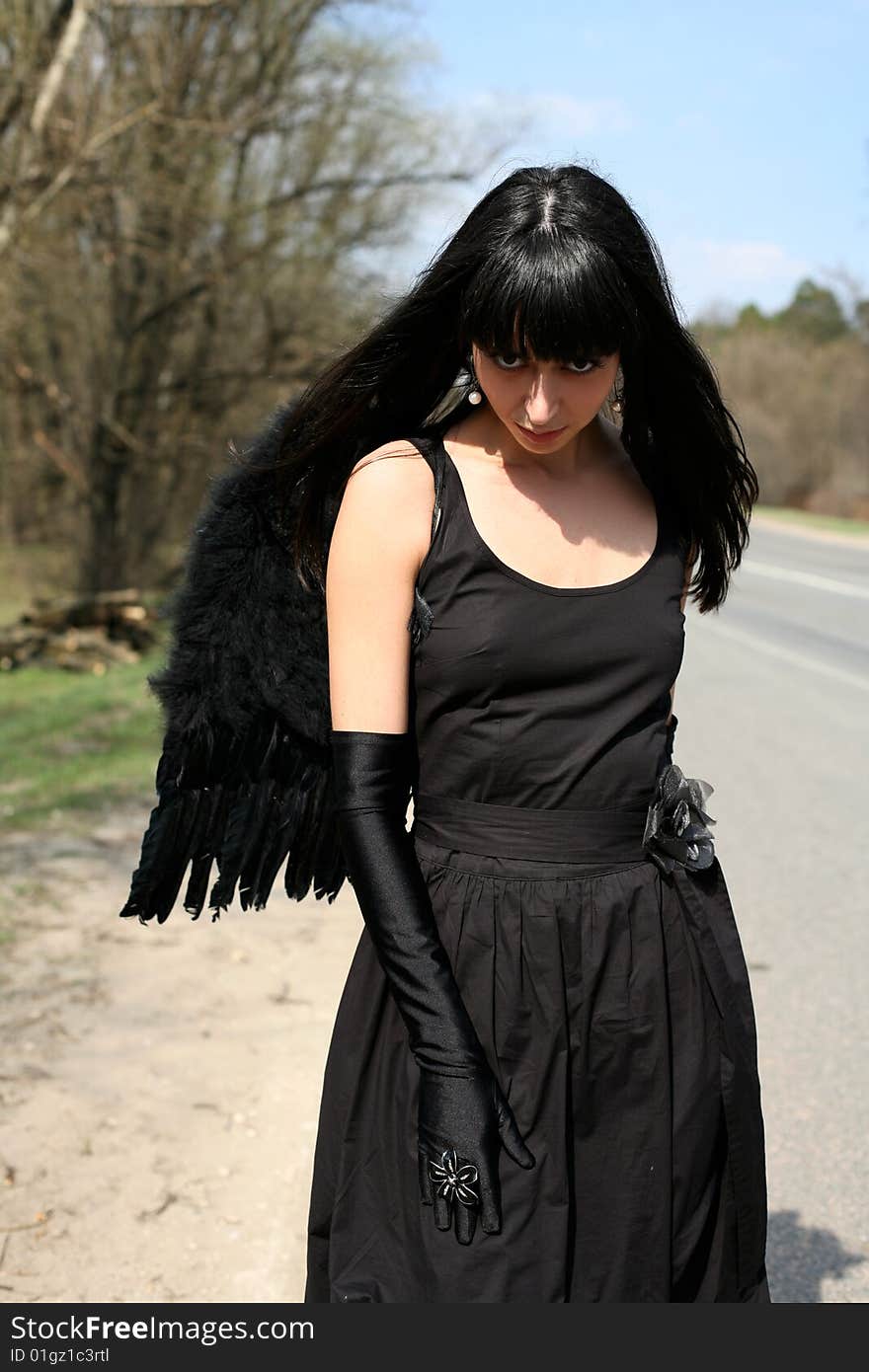 Black angel outdoors in the road