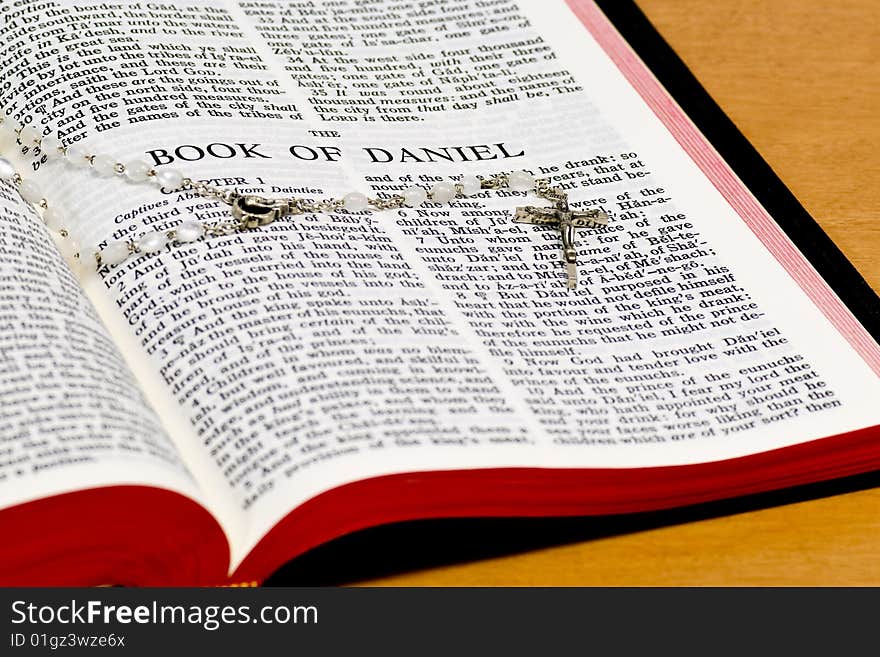 Close up of Daniel bible page with rosary. Close up of Daniel bible page with rosary