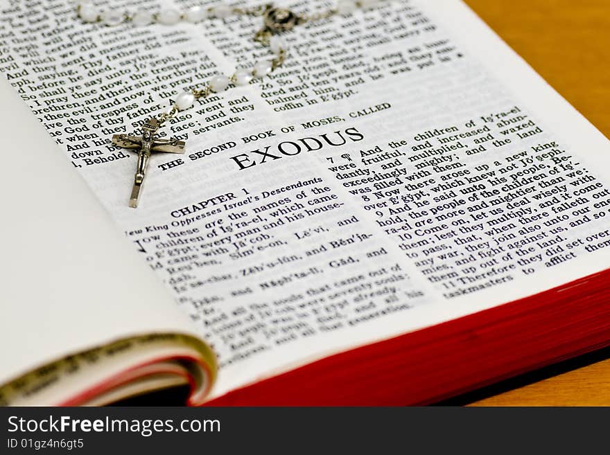 Close up of Exodus bible page with rosary. Close up of Exodus bible page with rosary