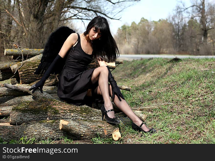 Sitting lovely black angel outdoors