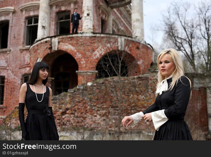 Two girl and man beside old house. Two girl and man beside old house