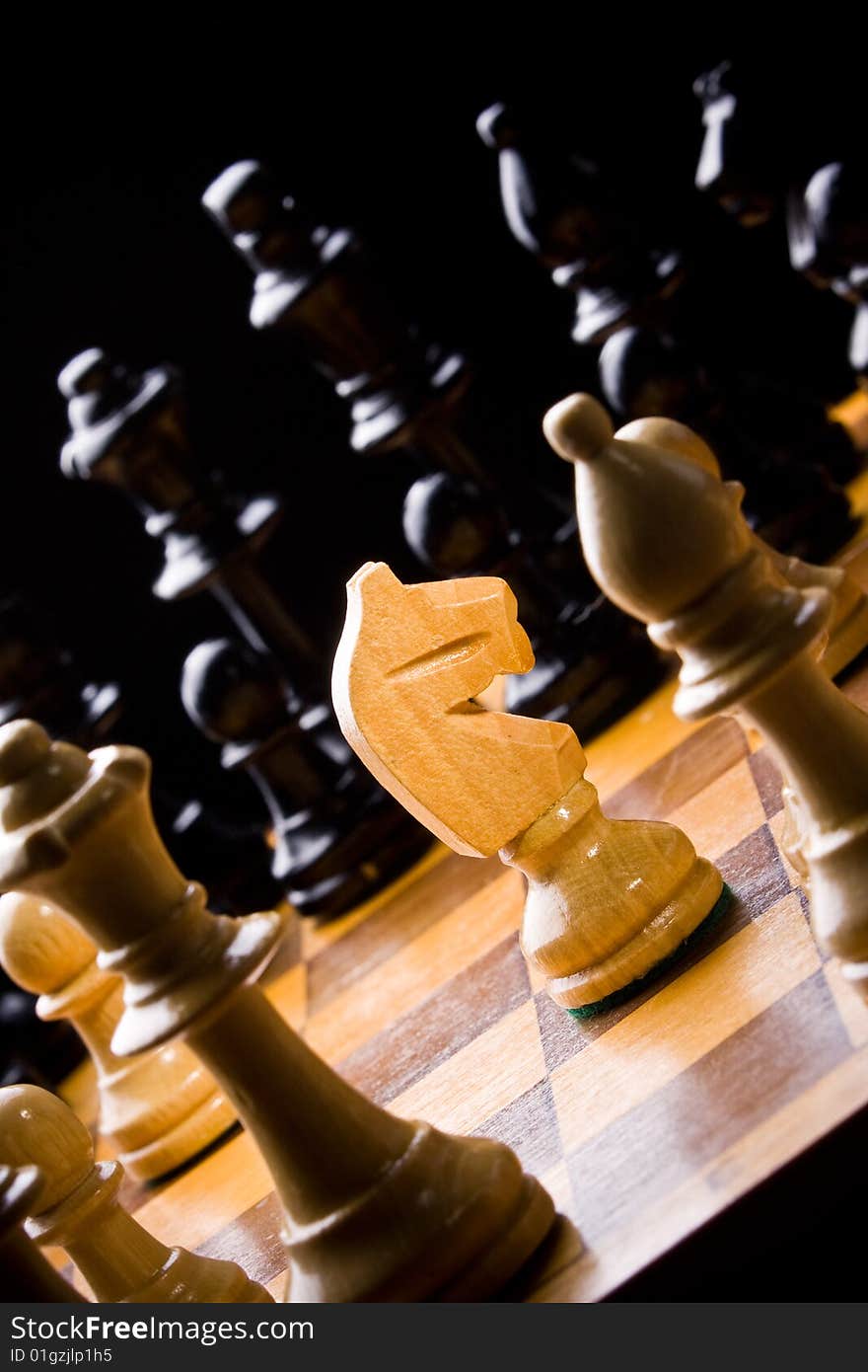 Old Craved wooden Chess pieces on a Board