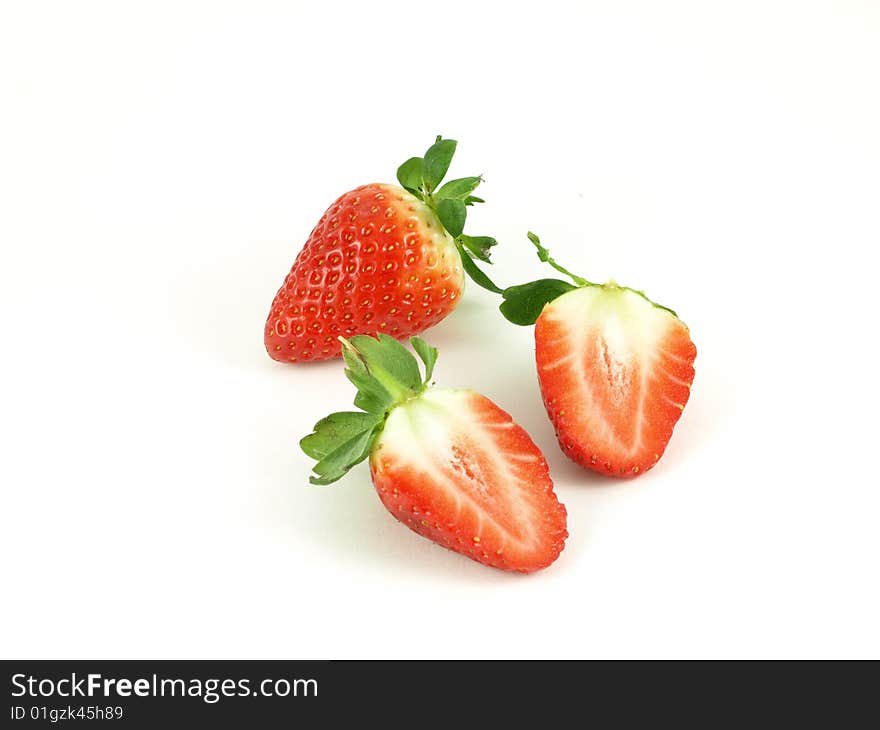 Strawberries halved on white studio isolated background.