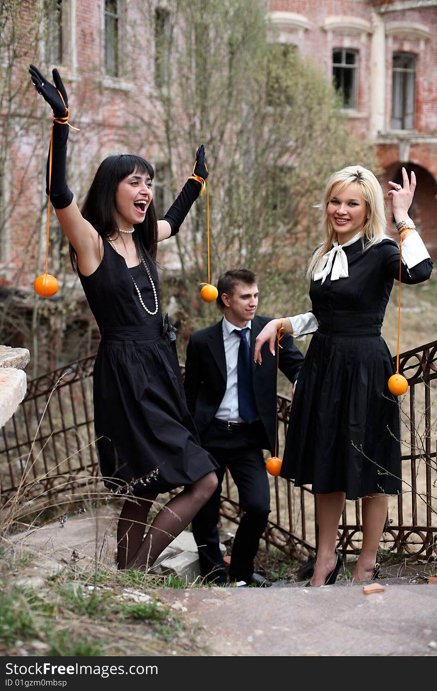 Two girl with oranges and man beside old house. Two girl with oranges and man beside old house