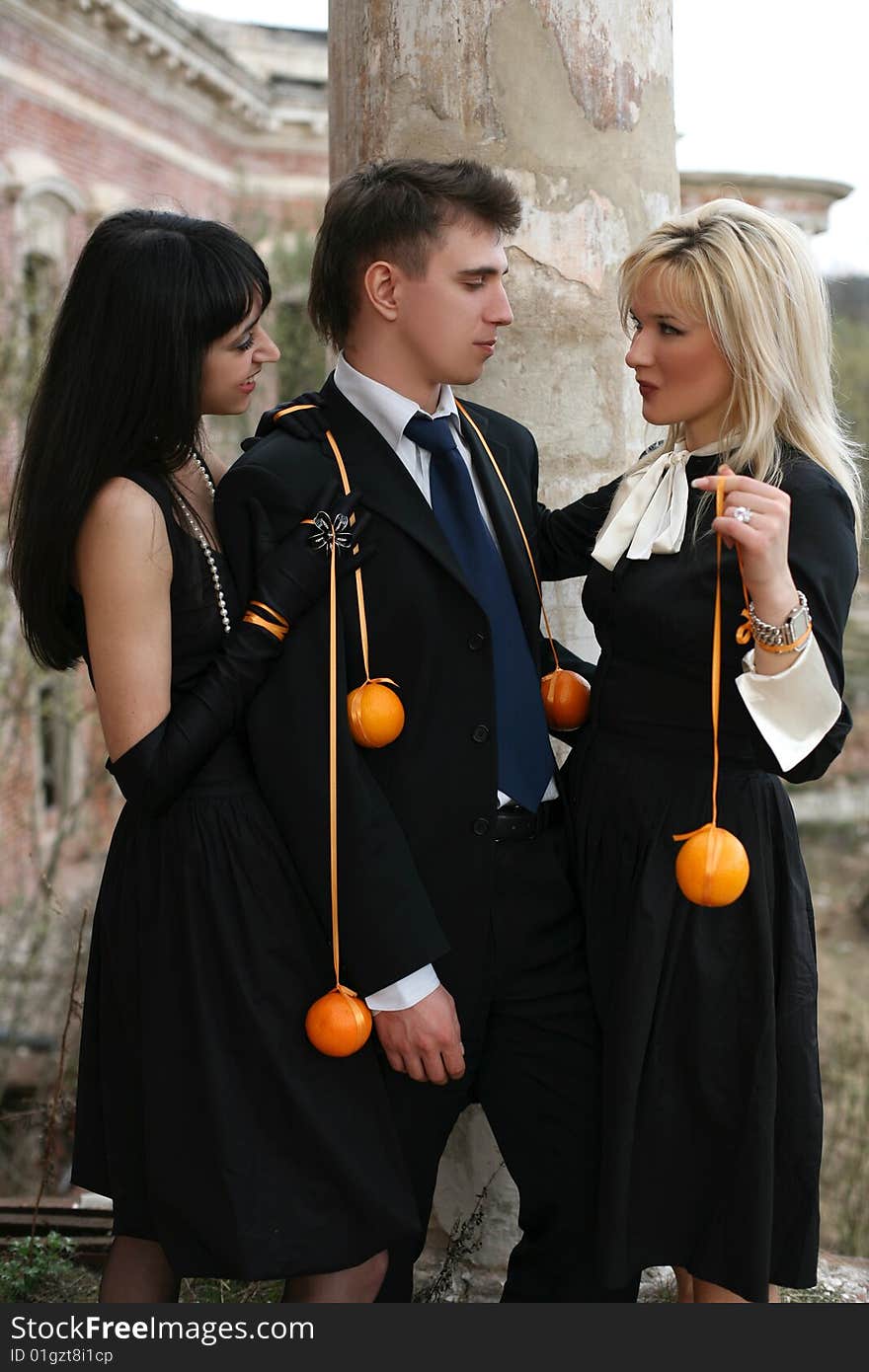 Two girl with oranges and man beside old house. Two girl with oranges and man beside old house