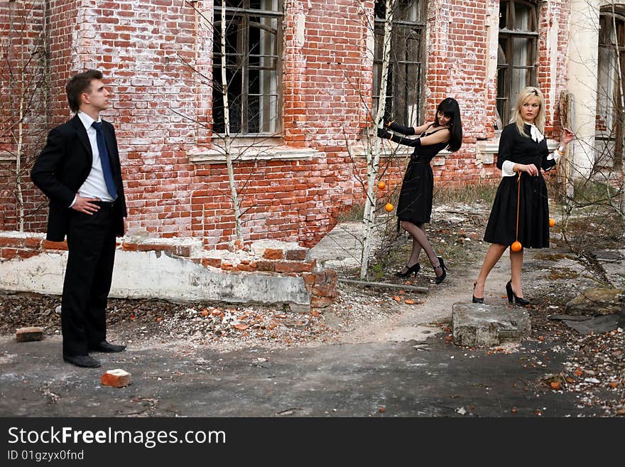 Two girl with oranges and man beside old house. Two girl with oranges and man beside old house