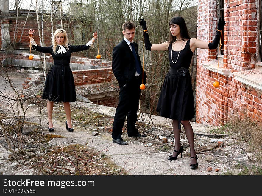 Two girl with oranges and man beside old house. Two girl with oranges and man beside old house