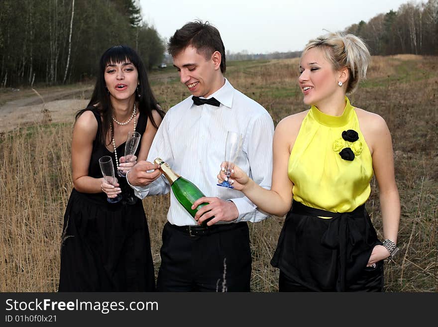 Two girl and man with wine outdoors. Two girl and man with wine outdoors