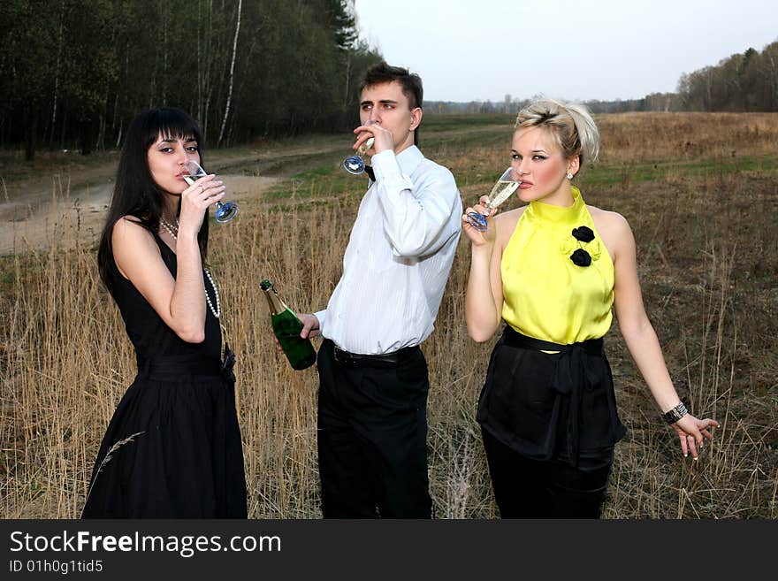 Two girl and man with wine outdoors. Two girl and man with wine outdoors