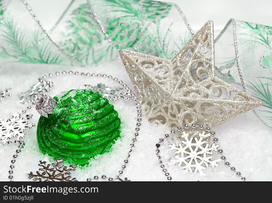 Green festive decoration and star on snow