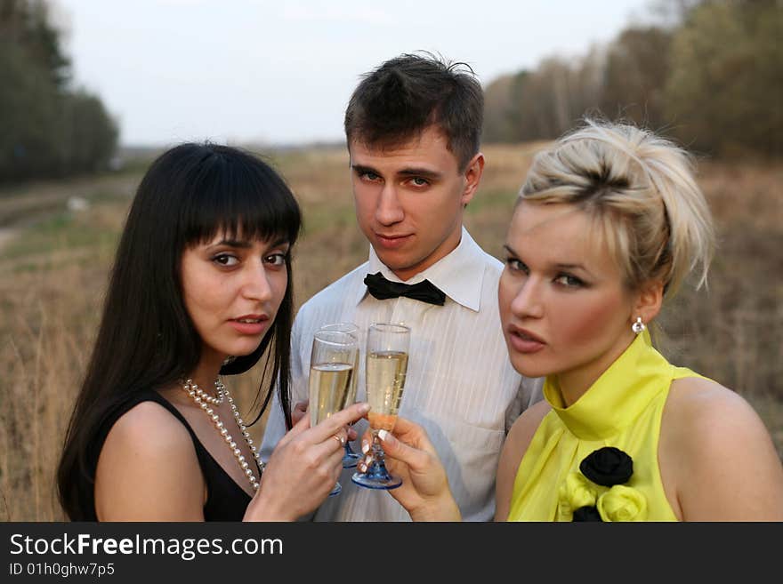 Two girl and man with wine outdoors. Two girl and man with wine outdoors