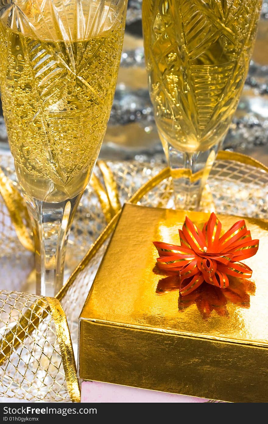 Glasses with champagne and gift box