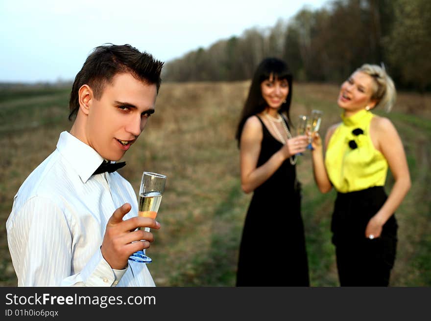 Two girl and man with wine outdoors. Two girl and man with wine outdoors