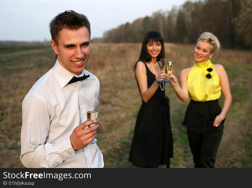 Two girl and man with wine outdoors. Two girl and man with wine outdoors