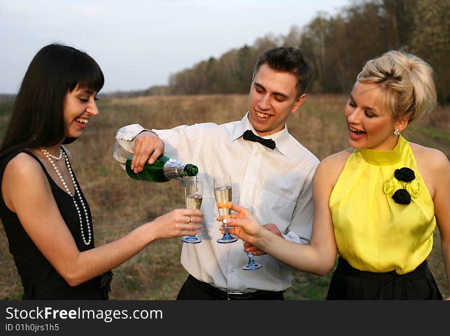 Two girl and man with wine outdoors. Two girl and man with wine outdoors