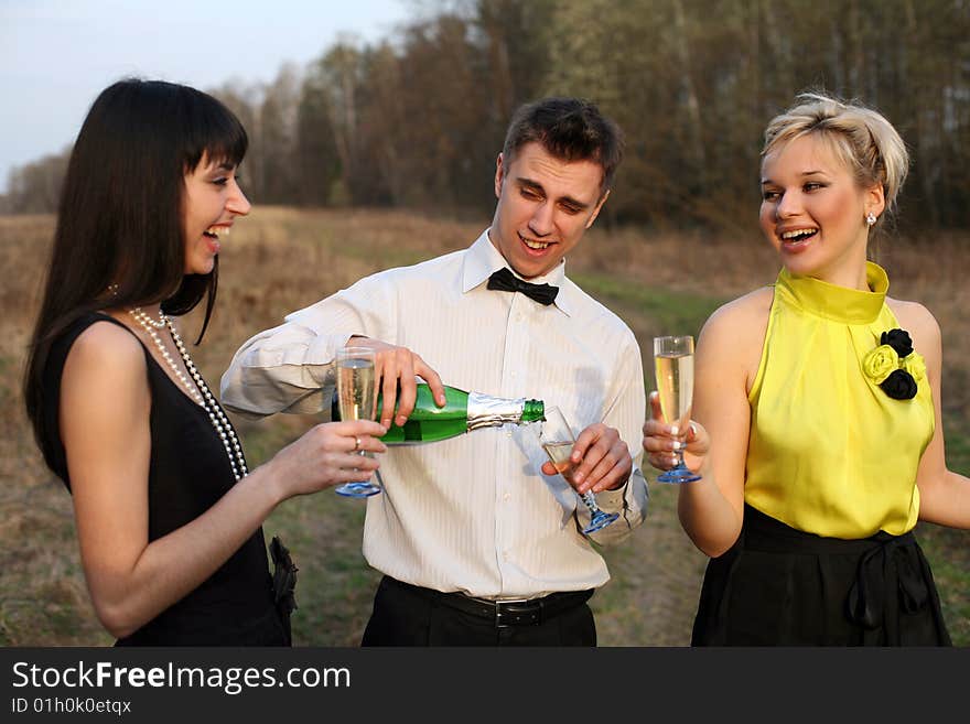 Two girl and man with wine outdoors. Two girl and man with wine outdoors