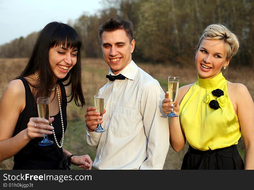 Two girl and man with wine outdoors. Two girl and man with wine outdoors