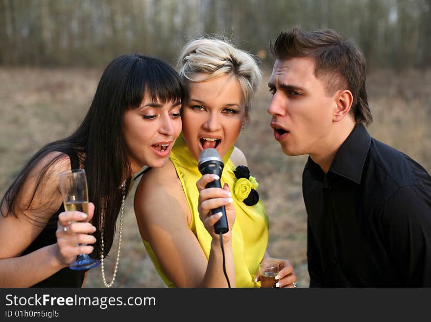 Singers trio with mic outdoors