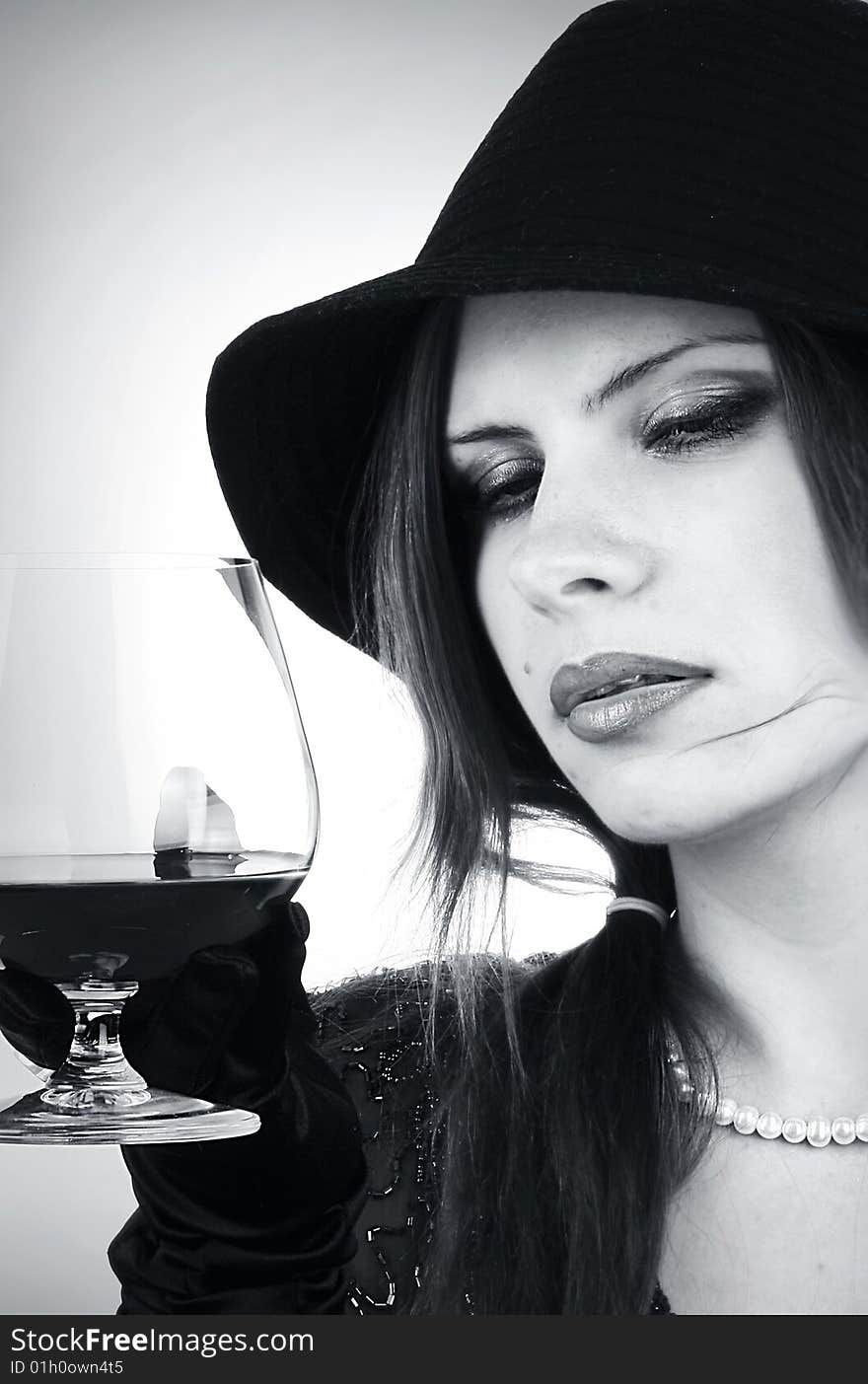 Portrait of the beautiful brunette with a cognac glass