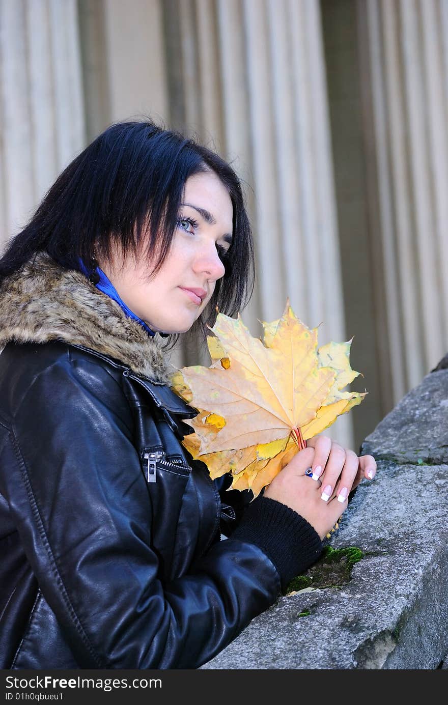 The girl with maple leaves near an ancient ladder. The girl with maple leaves near an ancient ladder