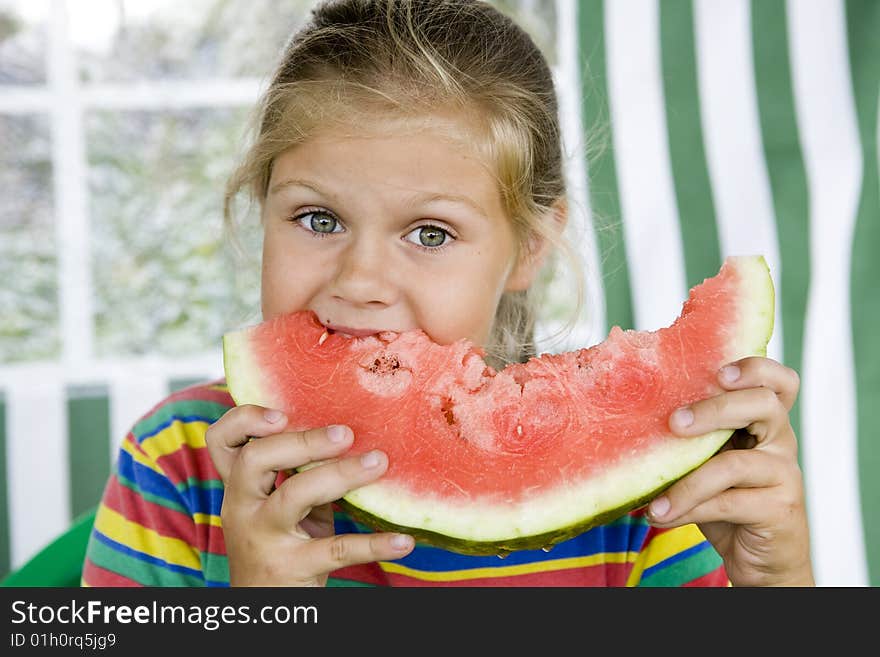 Little blond girl with a piece of watermelon in her hands. Little blond girl with a piece of watermelon in her hands