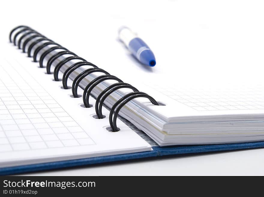 Blank notebook with blue pen on white background, closeup view