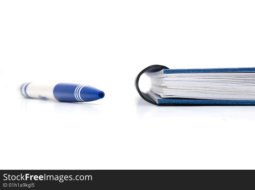 Blue notebook with blue pen laying on white background