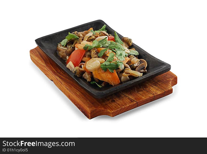 Mushrooms with meat on a frying pan and a wooden support on a white background. Mushrooms with meat on a frying pan and a wooden support on a white background