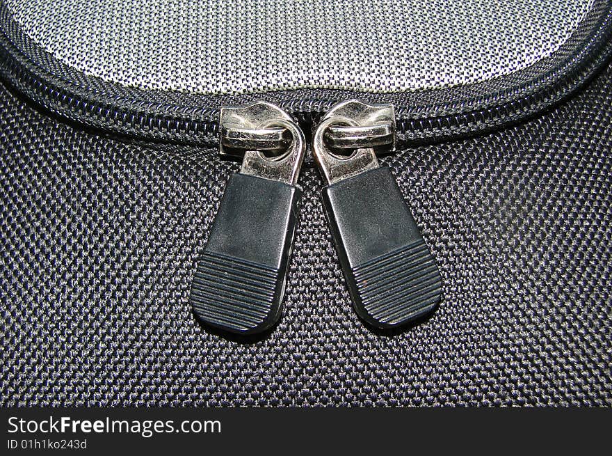 Close up of a closed zipper on grey texture