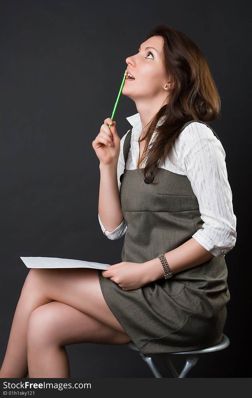 Pensive woman with a notebook against a dark background. Pensive woman with a notebook against a dark background