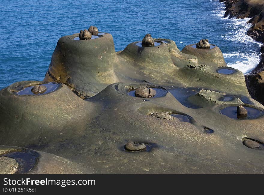 These are strange rocks form from coastal erosion. They look like nests with a single egg on them. Probably wind and water erosion. This is on Taiwan's coastline. These are strange rocks form from coastal erosion. They look like nests with a single egg on them. Probably wind and water erosion. This is on Taiwan's coastline.