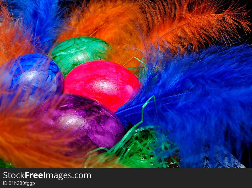 Colorful Easter eggs on the colored feathers