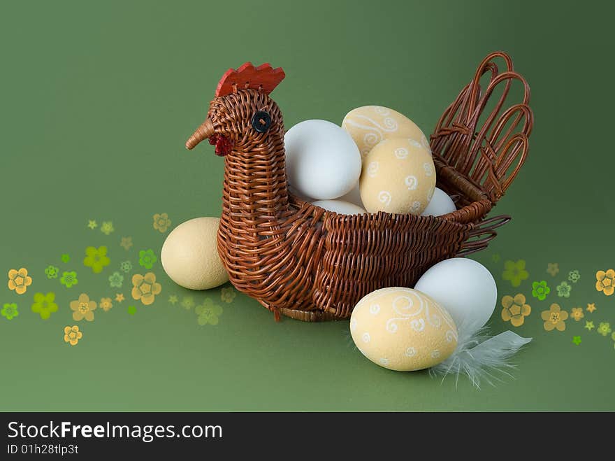 Easter eggs with basket on green background