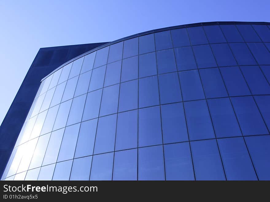 Modern glass office building of dark blue colour. Modern glass office building of dark blue colour