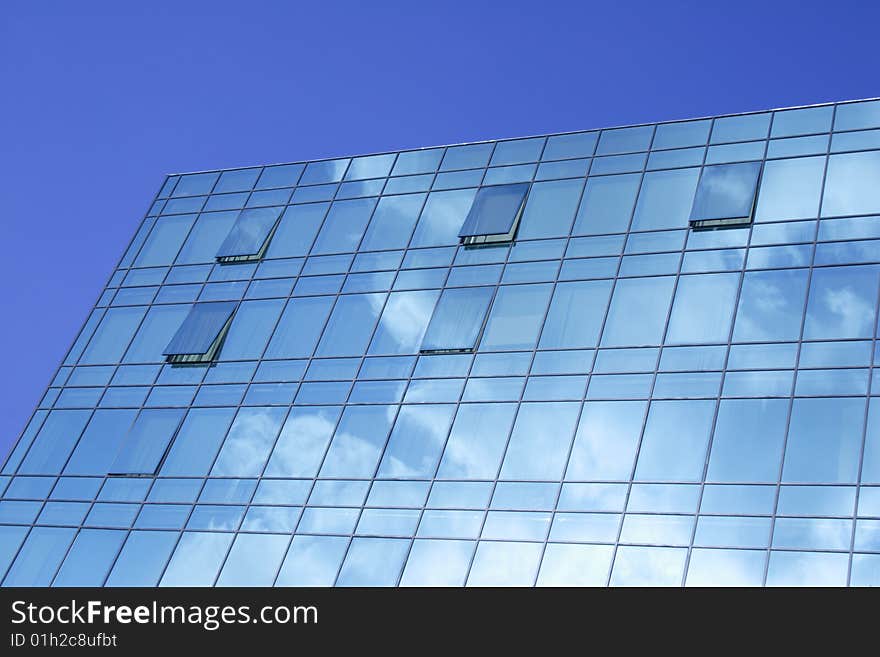 Modern glass office building of dark blue colour. Modern glass office building of dark blue colour