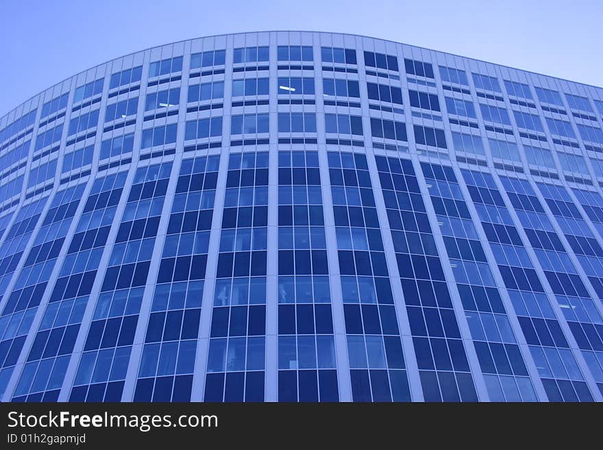 Modern glass office building of dark blue colour. Modern glass office building of dark blue colour