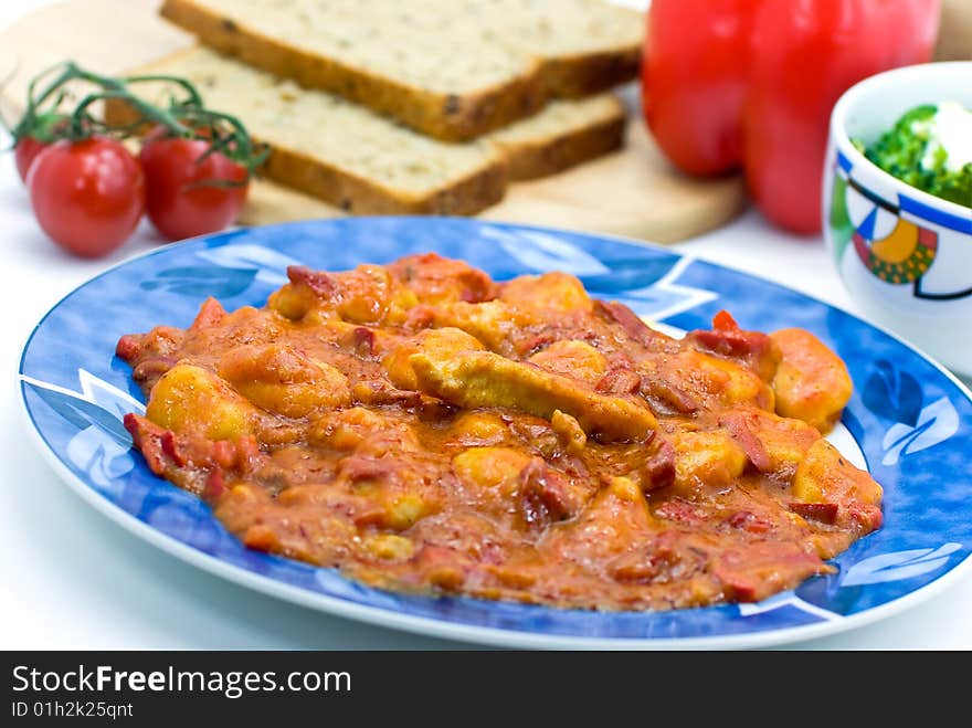 Slice of meat with dumplings-Gnocchi- and red bell pepper  sauce.