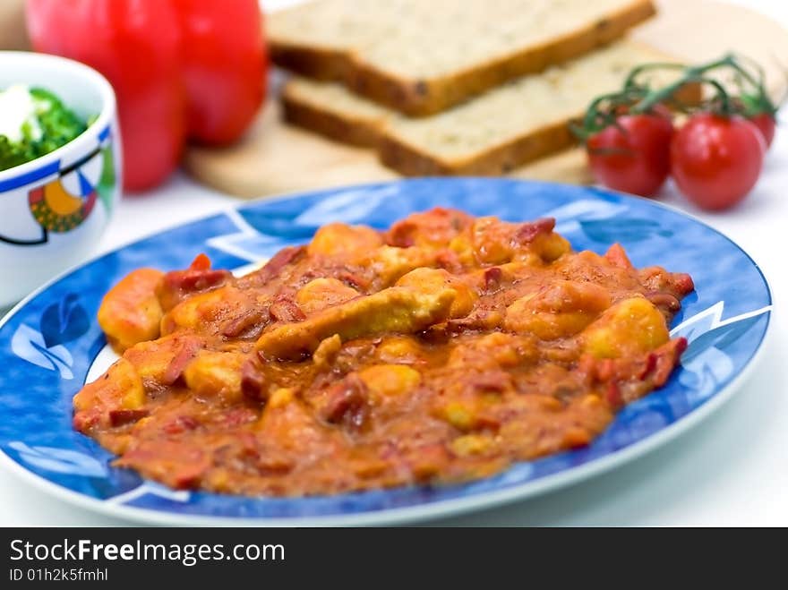 Slice of meat with dumplings-Gnocchi- and red bell pepper  sauce.