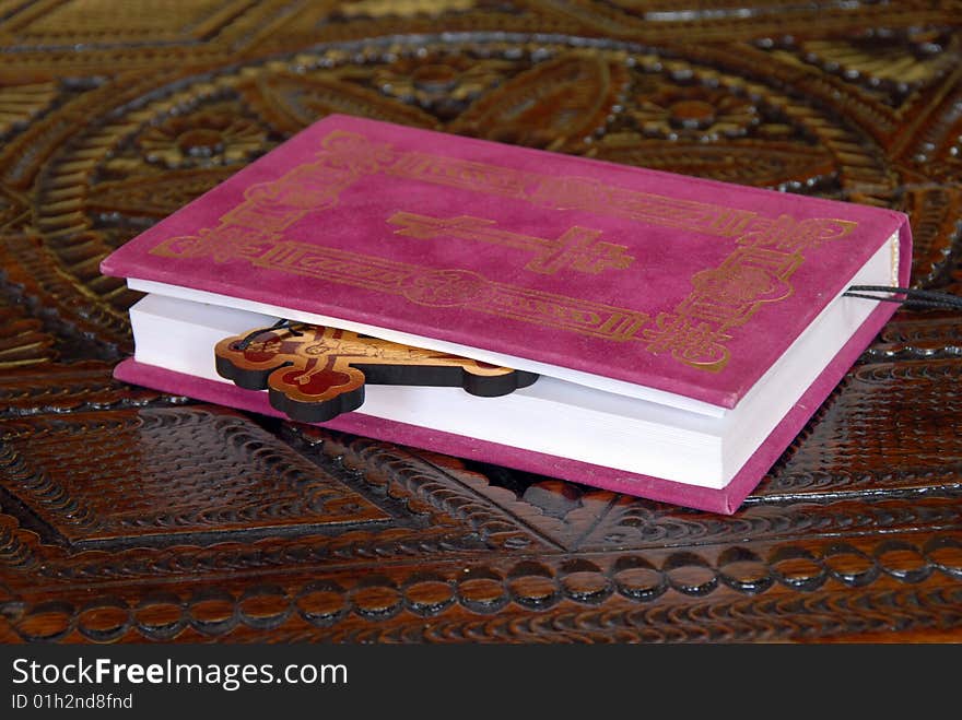 Red Bible book with wooden cross on table. Red Bible book with wooden cross on table