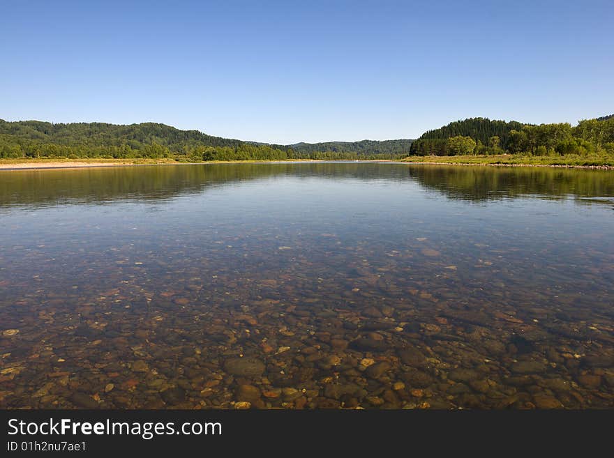 Blue river with pebbles landscape