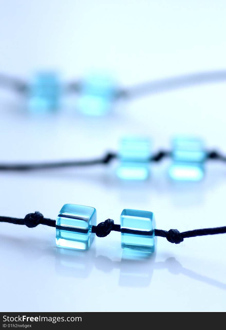 Pair of blue cube beads on navy blue strings. Pair of blue cube beads on navy blue strings