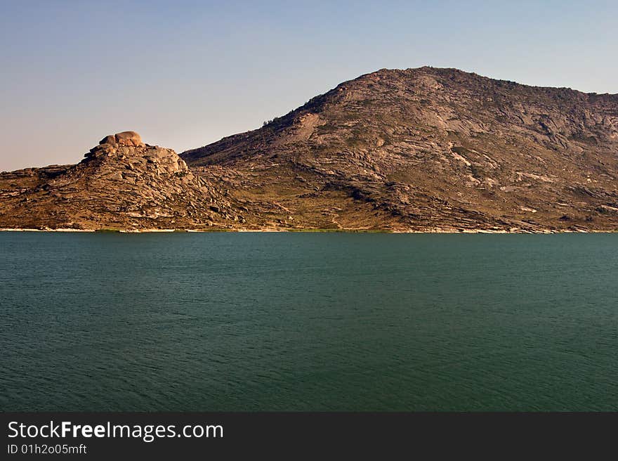 Lake and mountains landscape with blue sky