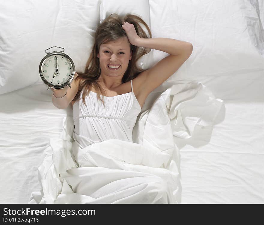 Woman in bed with alarm clock